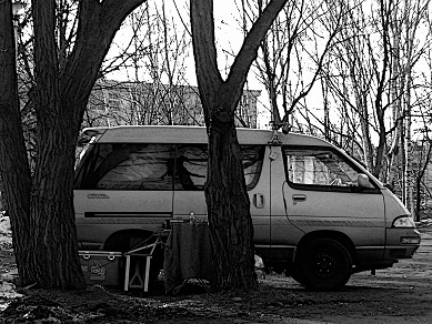 Homeless sleep in a van in a park.