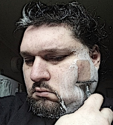 A man shaves his face with a razor.