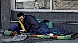 A homeless man sitting outside.