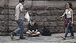 A homeless panhandler sitting down.